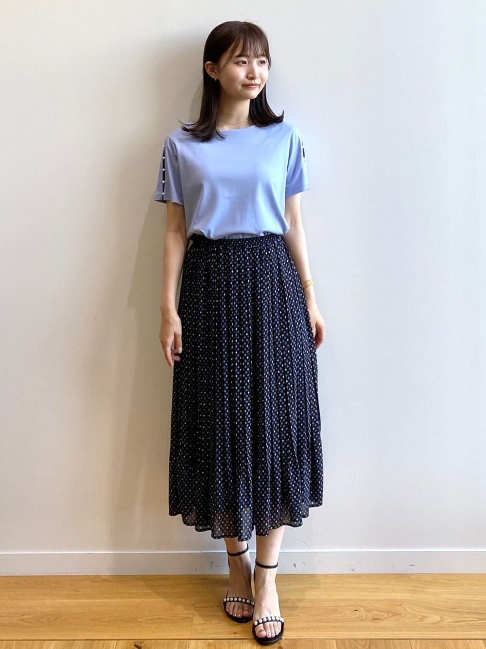 ブラック系のスカート、ブルー系のTシャツ/カットソー、ブラック系のサンダルを着用したレディースの夏コーディネートの1枚目の写真