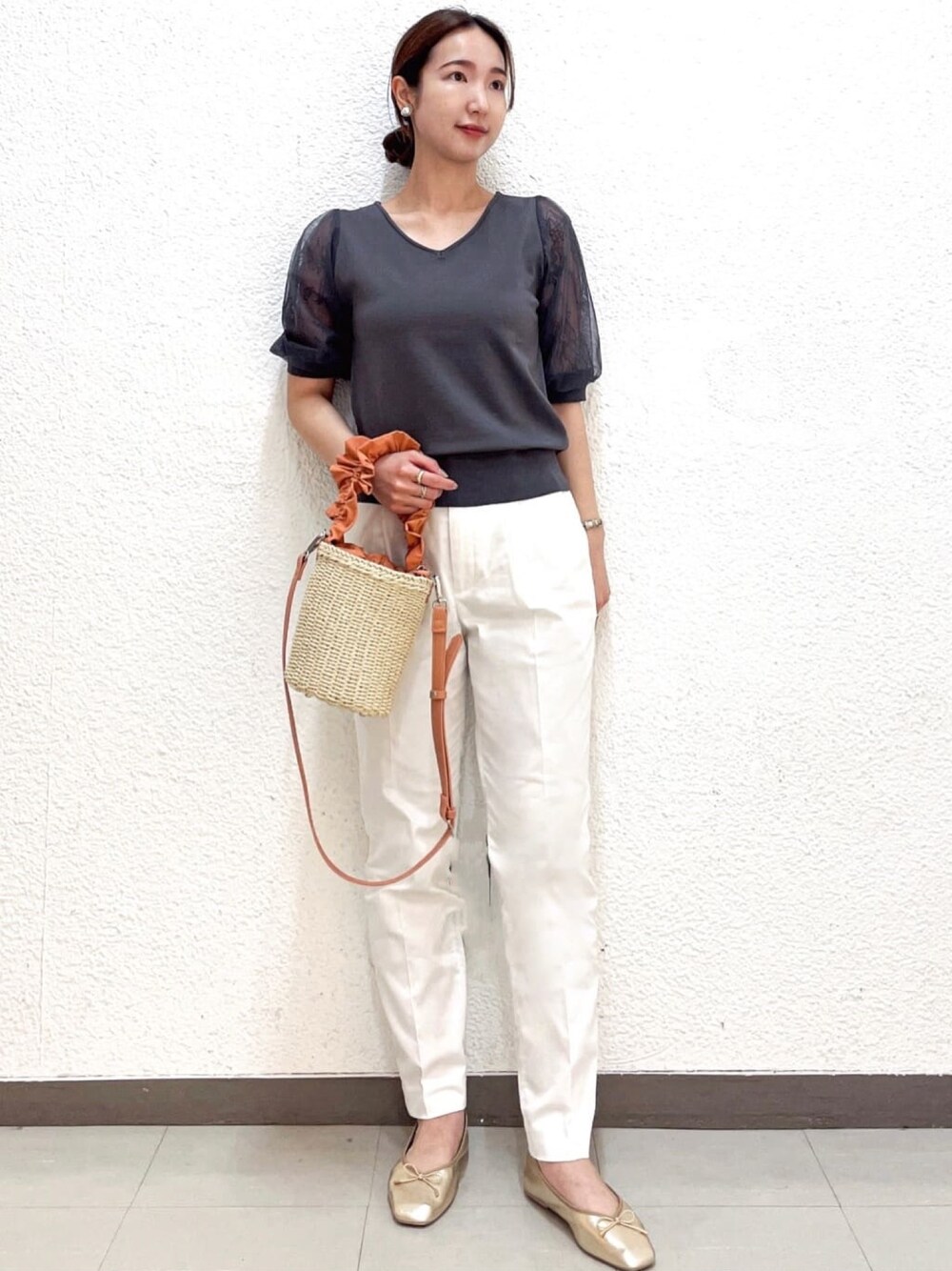 グレー系のニット/セーター、ホワイト系のその他パンツ、オレンジ系のショルダーバッグを着用したレディースの夏コーディネートの1枚目の写真