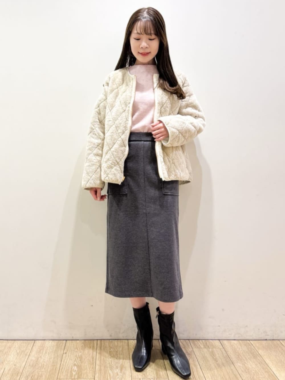 ホワイト系のブルゾン、ピンク系のニット/セーター、グレー系のスカートを着用したレディースの秋コーディネートの1枚目の写真