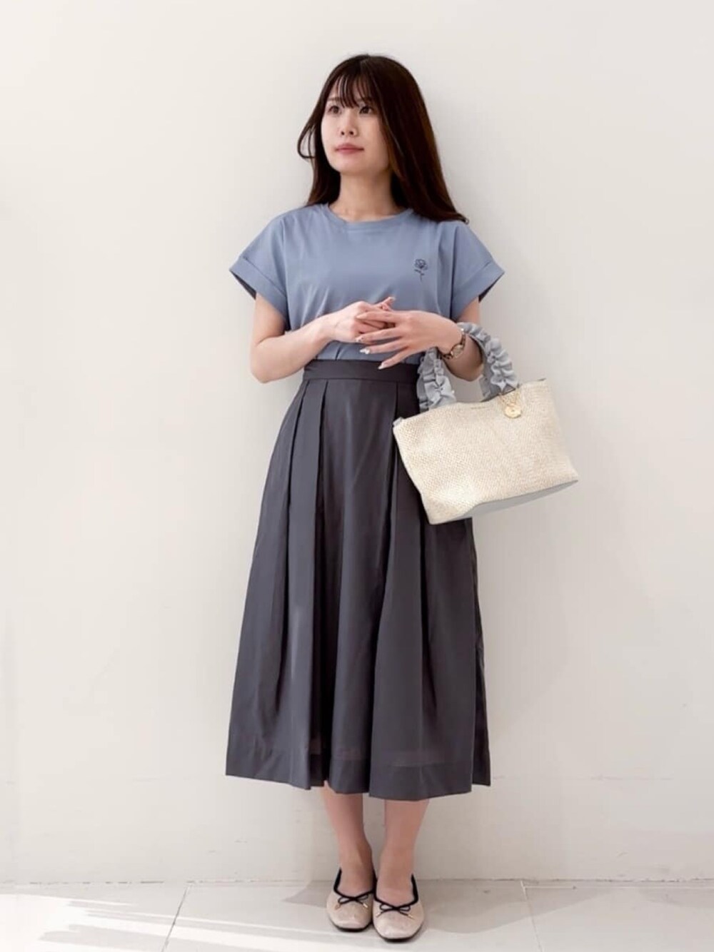 ブルー系のTシャツ/カットソー、グレー系のスカート、グレー系のトートバッグを着用したレディースの春コーディネートの1枚目の写真