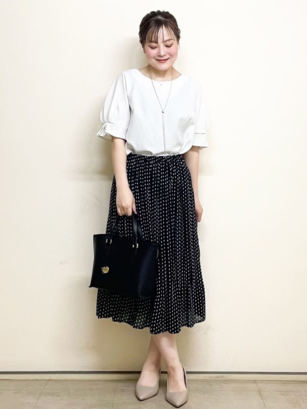 ホワイト系のシャツ/ブラウス、ブラック系のスカート、ブラック系のトートバッグを着用したレディースの春コーディネートの1枚目の写真