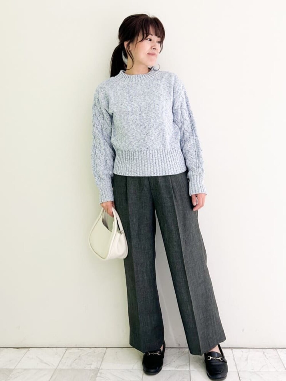 ブルー系のニット/セーター、グレー系のその他パンツ、ブラック系のパンプスを着用したレディースの冬コーディネートの1枚目の写真
