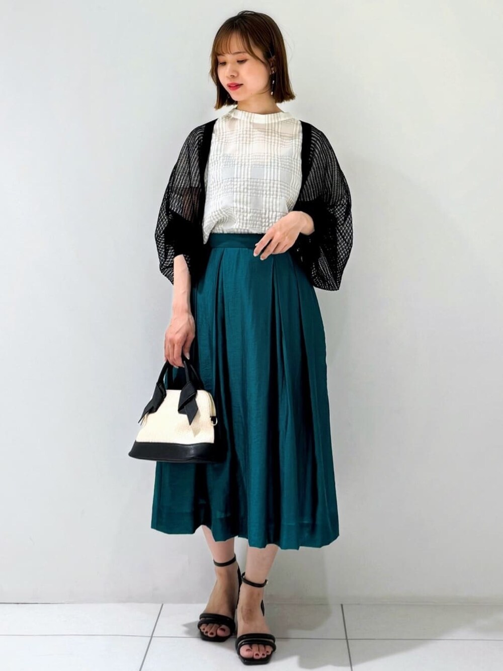 ブラック系のカーディガン/ボレロ、ベージュ系のシャツ/ブラウス、グリーン系のスカートを着用したレディースの夏コーディネートの1枚目の写真