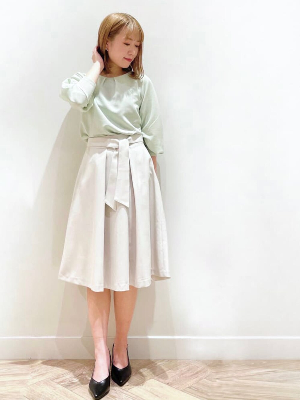 グリーン系のTシャツ/カットソー、グレー系のスカートを着用したレディースの春コーディネートの1枚目の写真