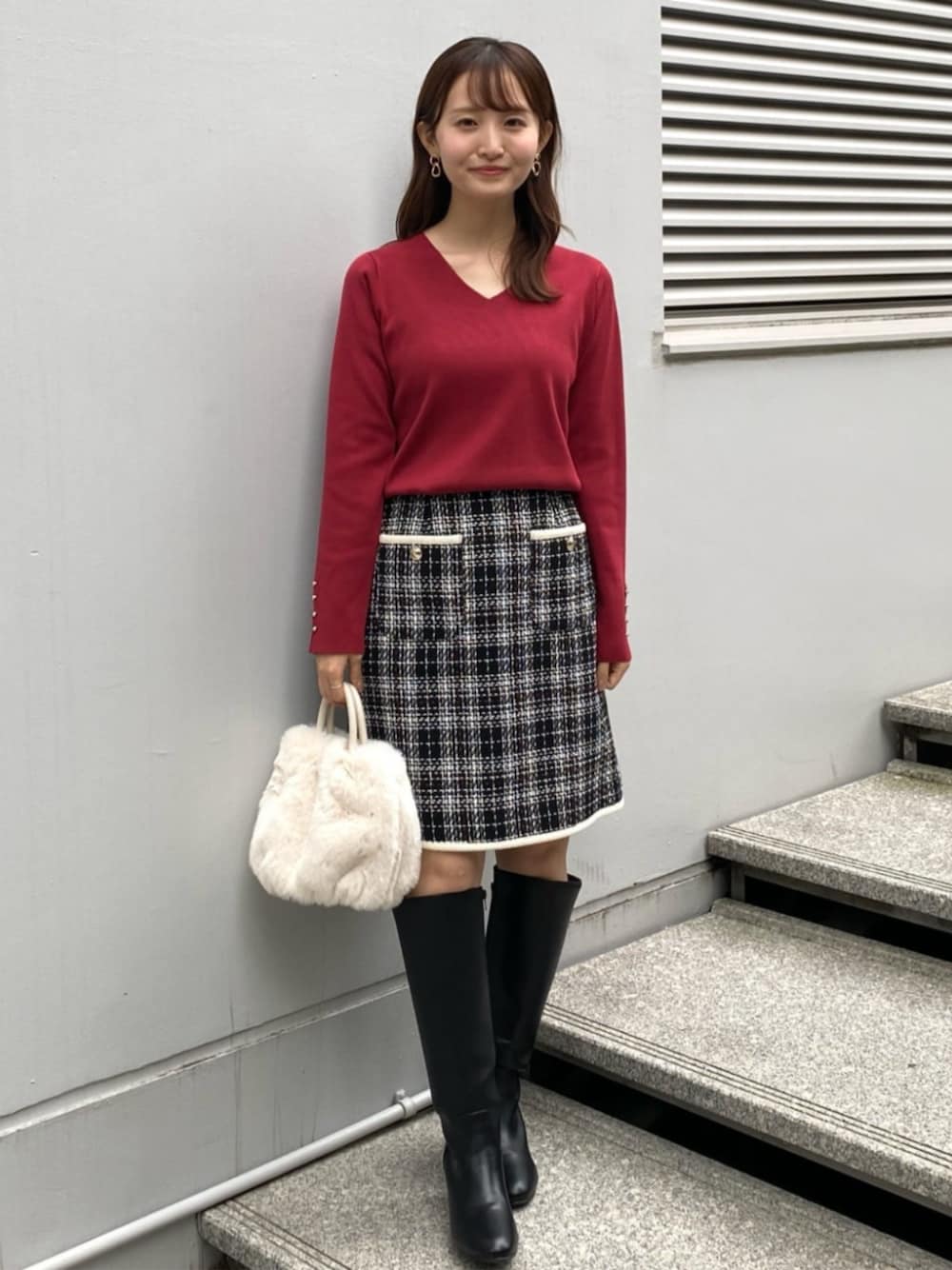 ブラック系のスカート、レッド系のニット/セーター、ホワイト系のショルダーバッグを着用したレディースの秋コーディネートの1枚目の写真