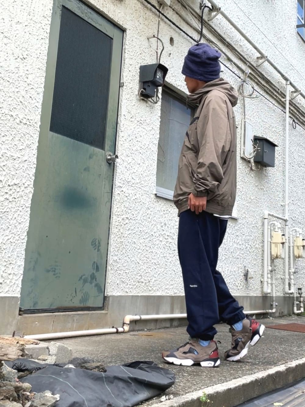 グレー系のスニーカー、ブルー系のスウェットパンツ、グレー系のブルゾンを着用したメンズの秋コーディネートの1枚目の写真