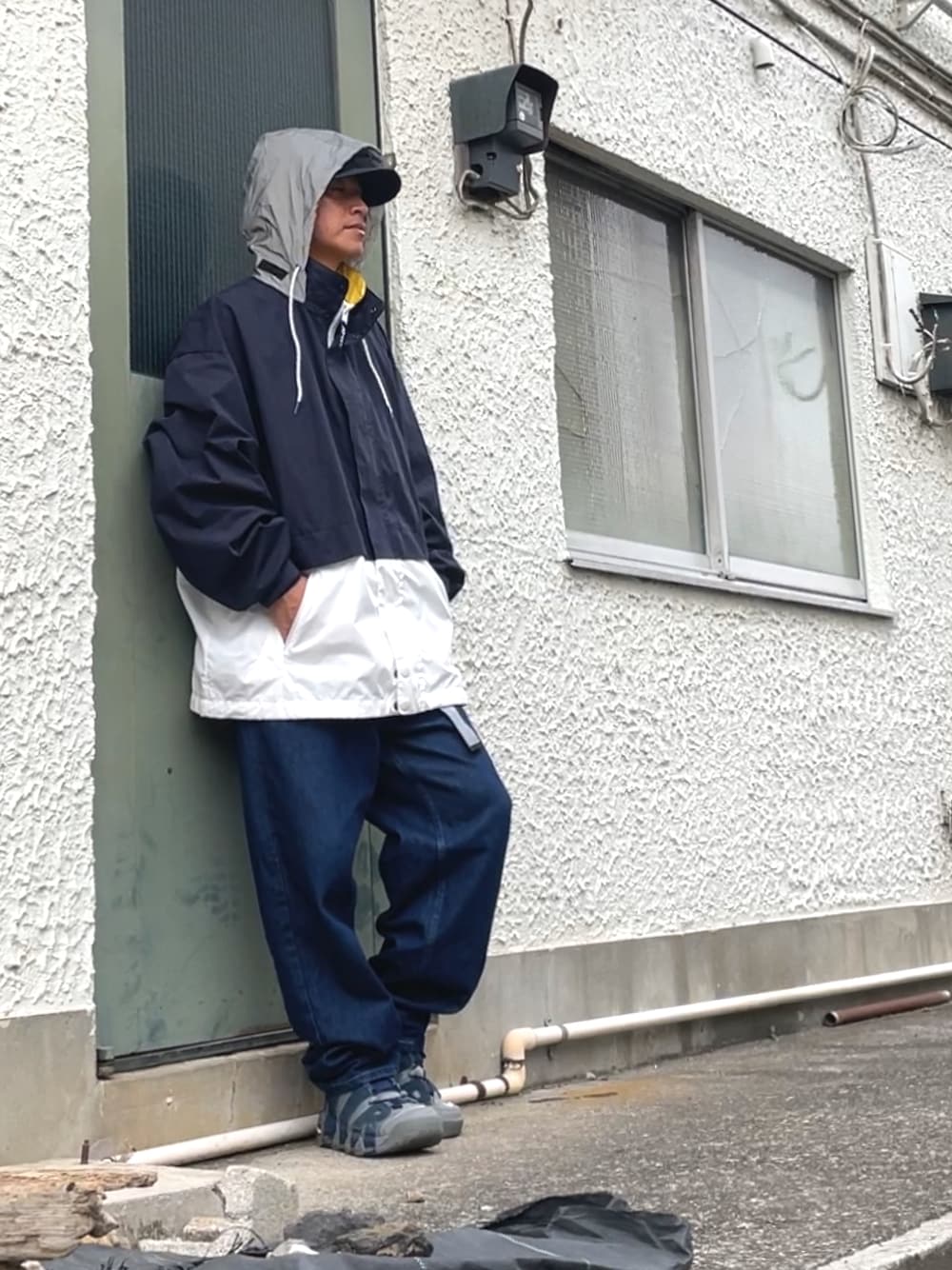 グレー系のスニーカー、ブルー系のデニムパンツ、その他のブルゾンを着用したメンズの秋コーディネートの1枚目の写真