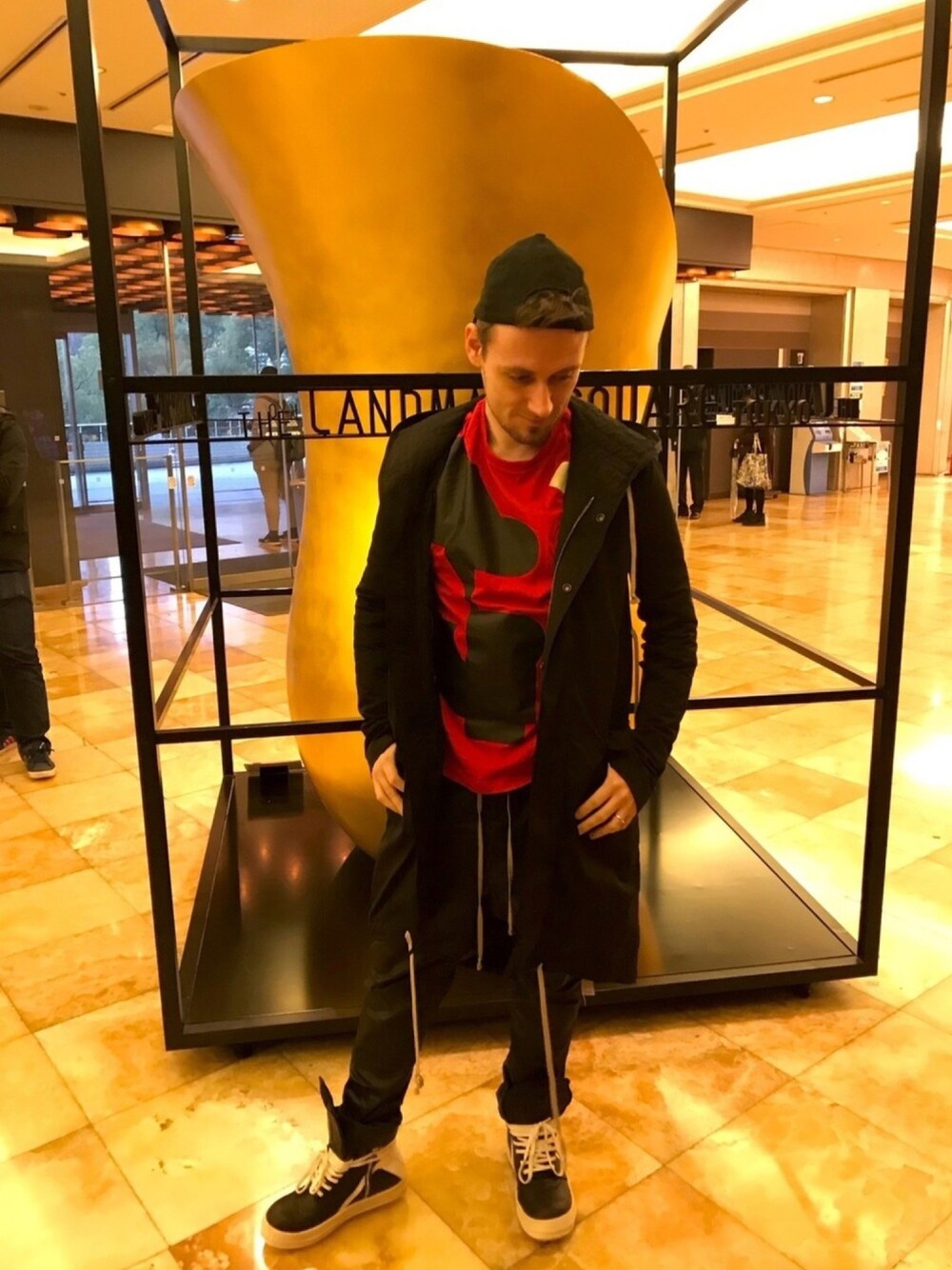 「モードストリート、キャップ後ろかぶり、ロゴT、オーバーコート、サルエルパンツ、ジオバス、geobasket、RICK OWENS、drkshdw、Y-3」｜「Y-3のU VARSITY SS TEE（Tシャツ/カットソー、レッド系）」を使った、塔弁さん（メンズ・172cm）の春コーディネートの1枚目の写真