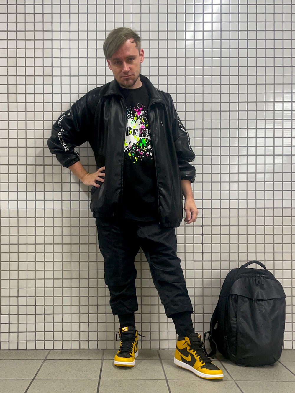「ストリート、オーバーサイズ、レイヤードスタイル、オールブラック、プリントT、レザージャケット、トラックジャケット、ナイロンパンツ、リュック、スニーカー、ハイカットスニーカー、AIR JORDAN、NIKE、blackeyepatch、Y-3」｜「DANKE SCHONのDankeSchon/ダンケシェーン/AMBER FOAM RUBBER S/S TEE（Tシャツ/カットソー、ブラック系）」を使った、塔弁さん（メンズ・172cm）の春コーディネートの1枚目の写真