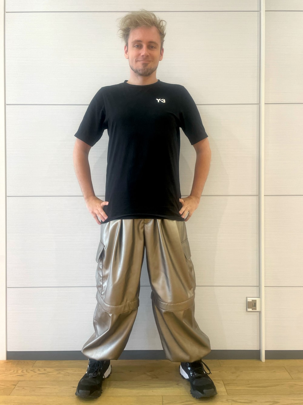 ゴールド系のカーゴパンツ、ブラック系のTシャツ/カットソー、ブラック系のスニーカーを着用したメンズの夏コーディネートの1枚目の写真
