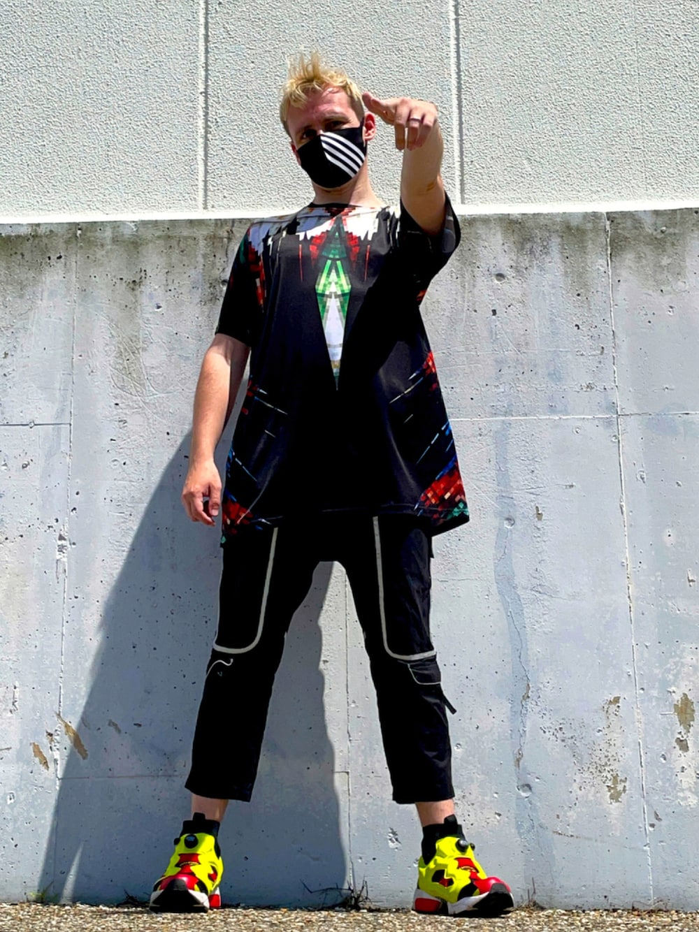 ブラック系のTシャツ/カットソー、ブラック系のパンツ、イエロー系のスニーカーを着用したメンズの夏コーディネートの1枚目の写真
