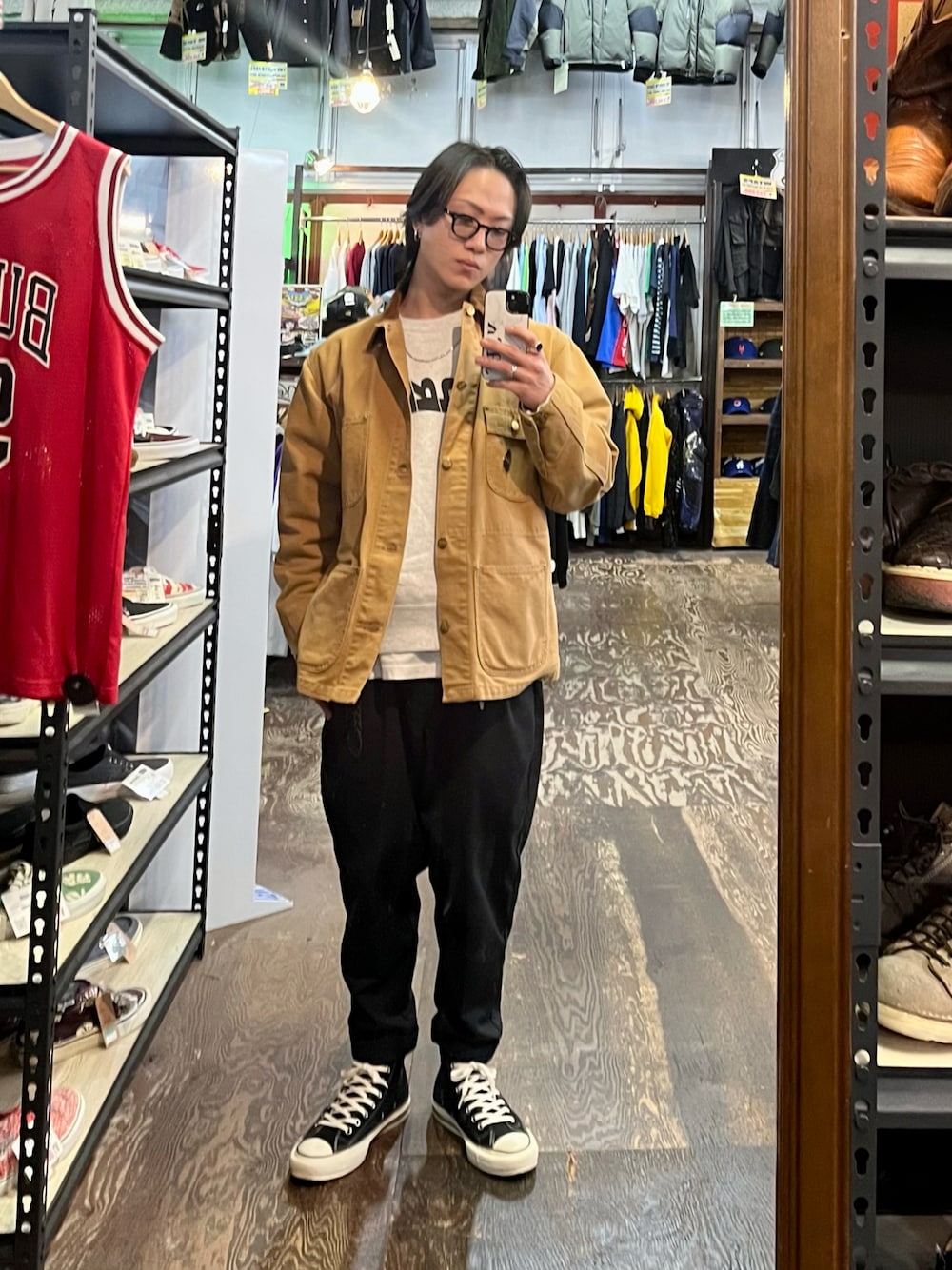 ベージュ系のカバーオール、ブラック系のスラックス、ブラック系のスニーカーを着用したメンズの秋コーディネートの1枚目の写真