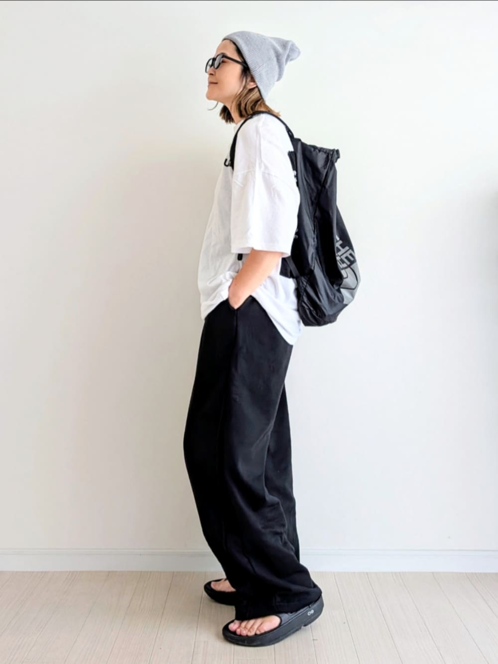 ブラック系のその他パンツ、ホワイト系のTシャツ/カットソー、ブラック系のサンダルを着用したレディースの夏コーディネートの1枚目の写真