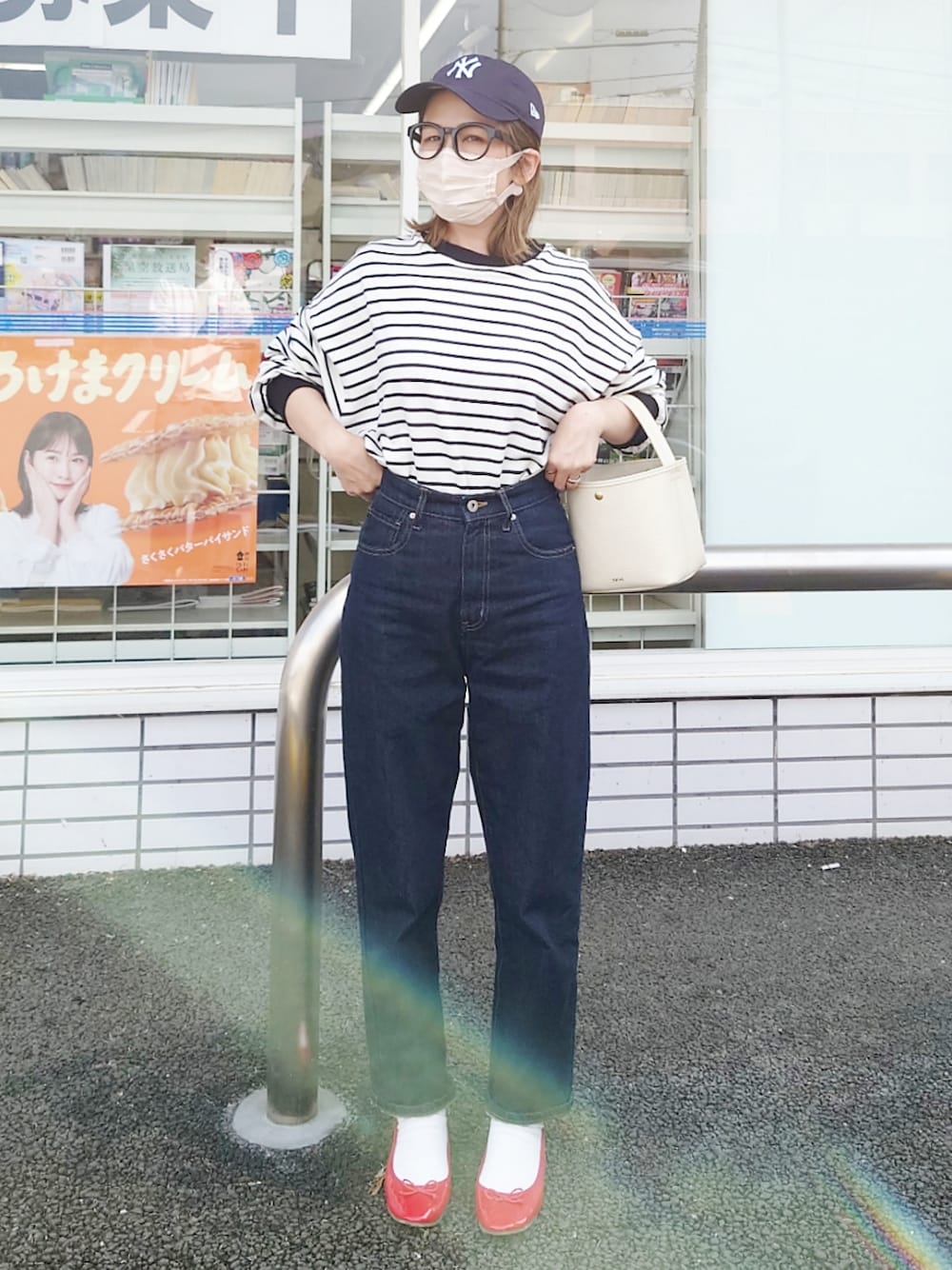 ブラック系のTシャツ/カットソー、ブルー系のデニムパンツ、ホワイト系のハンドバッグを着用したレディースの春コーディネートの1枚目の写真