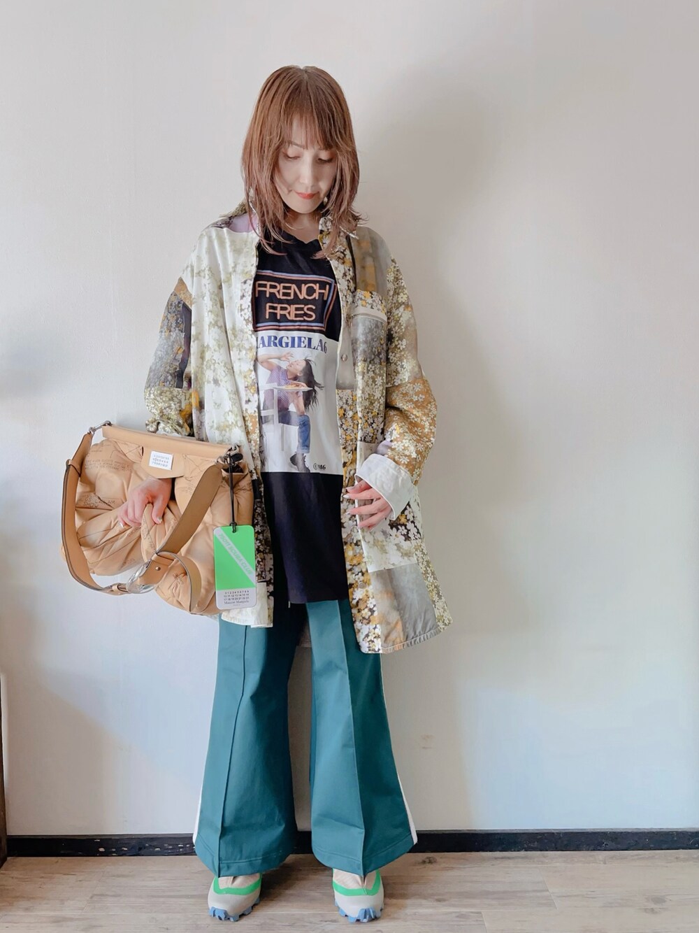 ブラック系のTシャツ/カットソー、グリーン系のパンツ、グリーン系のシューズを着用したレディースの春コーディネートの1枚目の写真