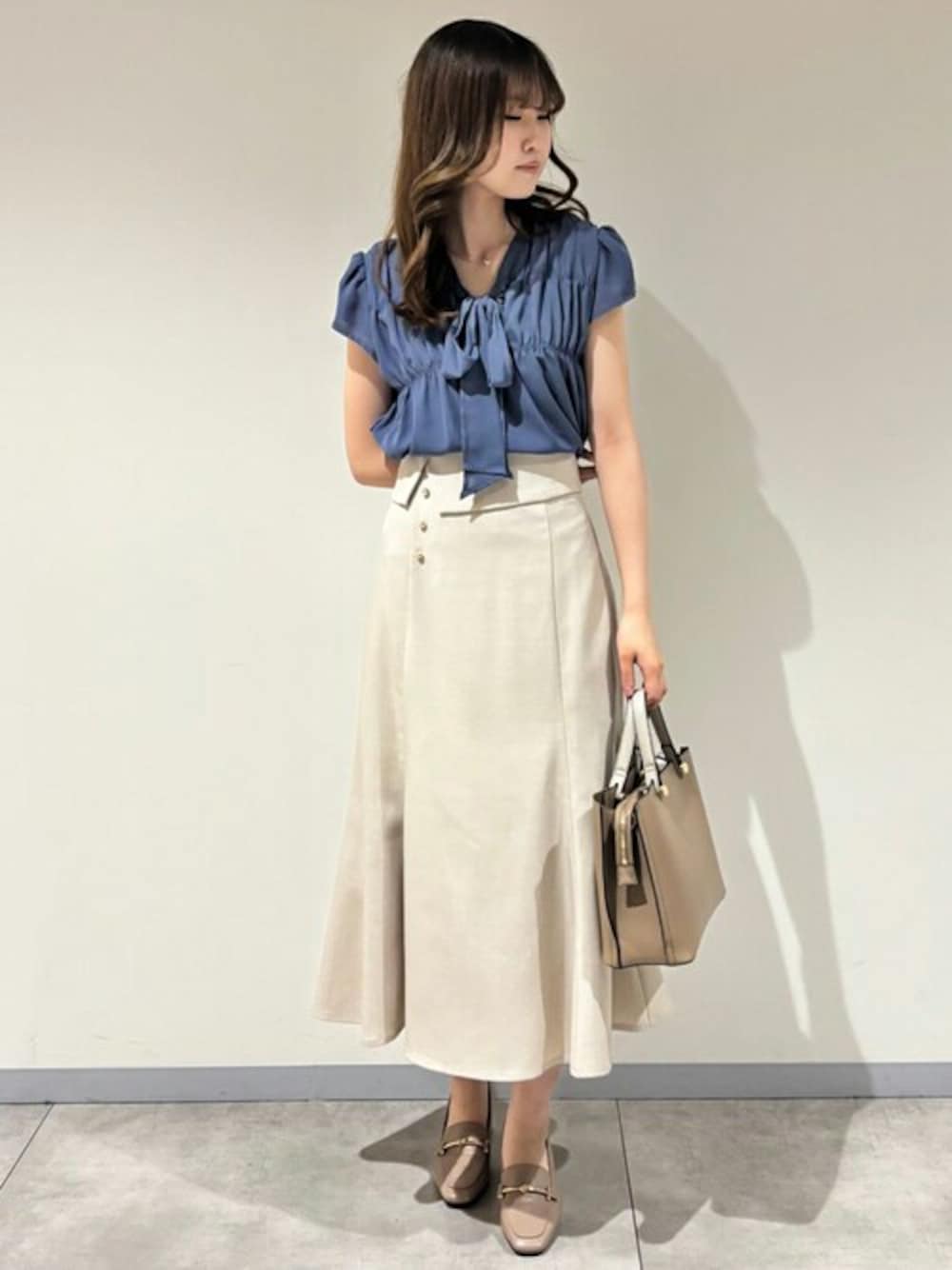 ブルー系のシャツ/ブラウス、ベージュ系のスカートを着用したレディースの夏コーディネートの1枚目の写真