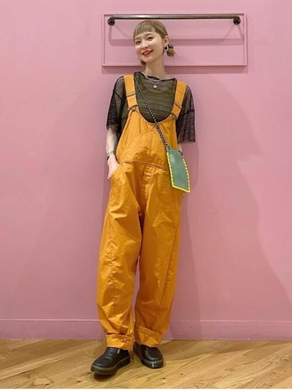 ブラック系のTシャツ/カットソー、オレンジ系のサロペット/オーバーオール、ブラック系のサンダルを着用したレディースの春コーディネートの1枚目の写真