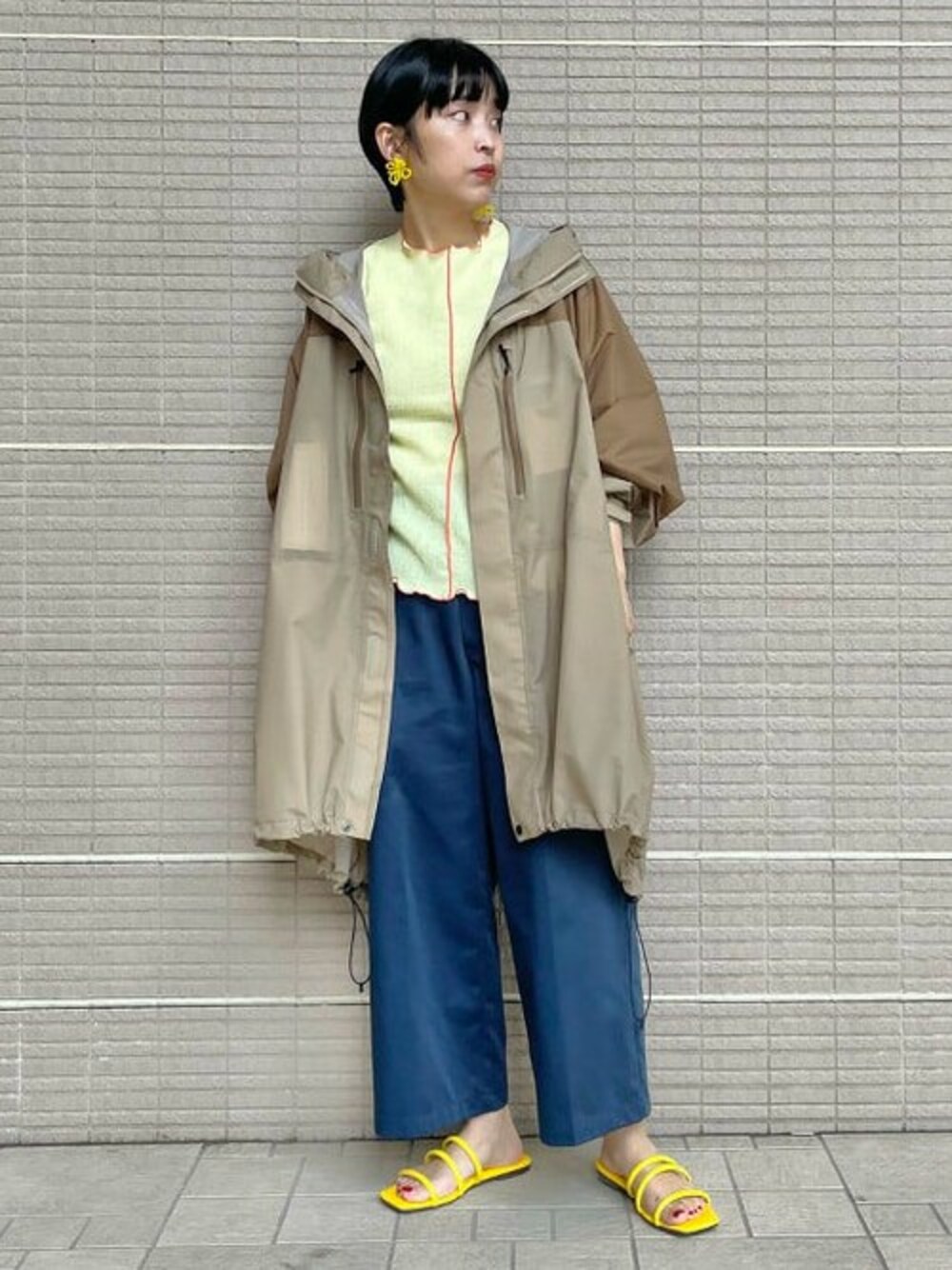 ベージュ系のTシャツ/カットソー、ブラウン系のポンチョ、イエロー系のサンダルを着用したレディースの夏コーディネートの1枚目の写真