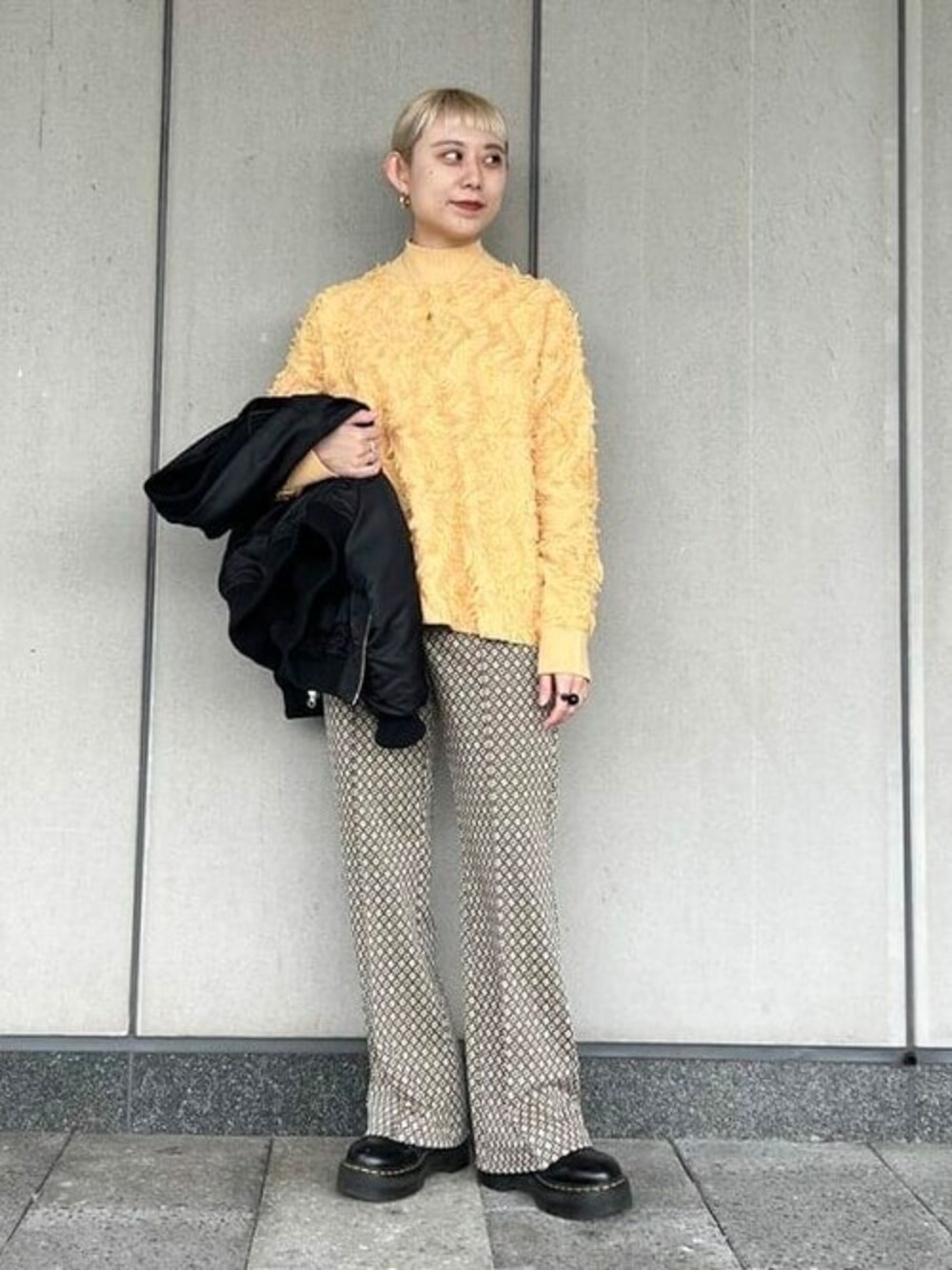 イエロー系のニット/セーター、ベージュ系のその他パンツ、その他のネックレスを着用したレディースの夏コーディネートの1枚目の写真