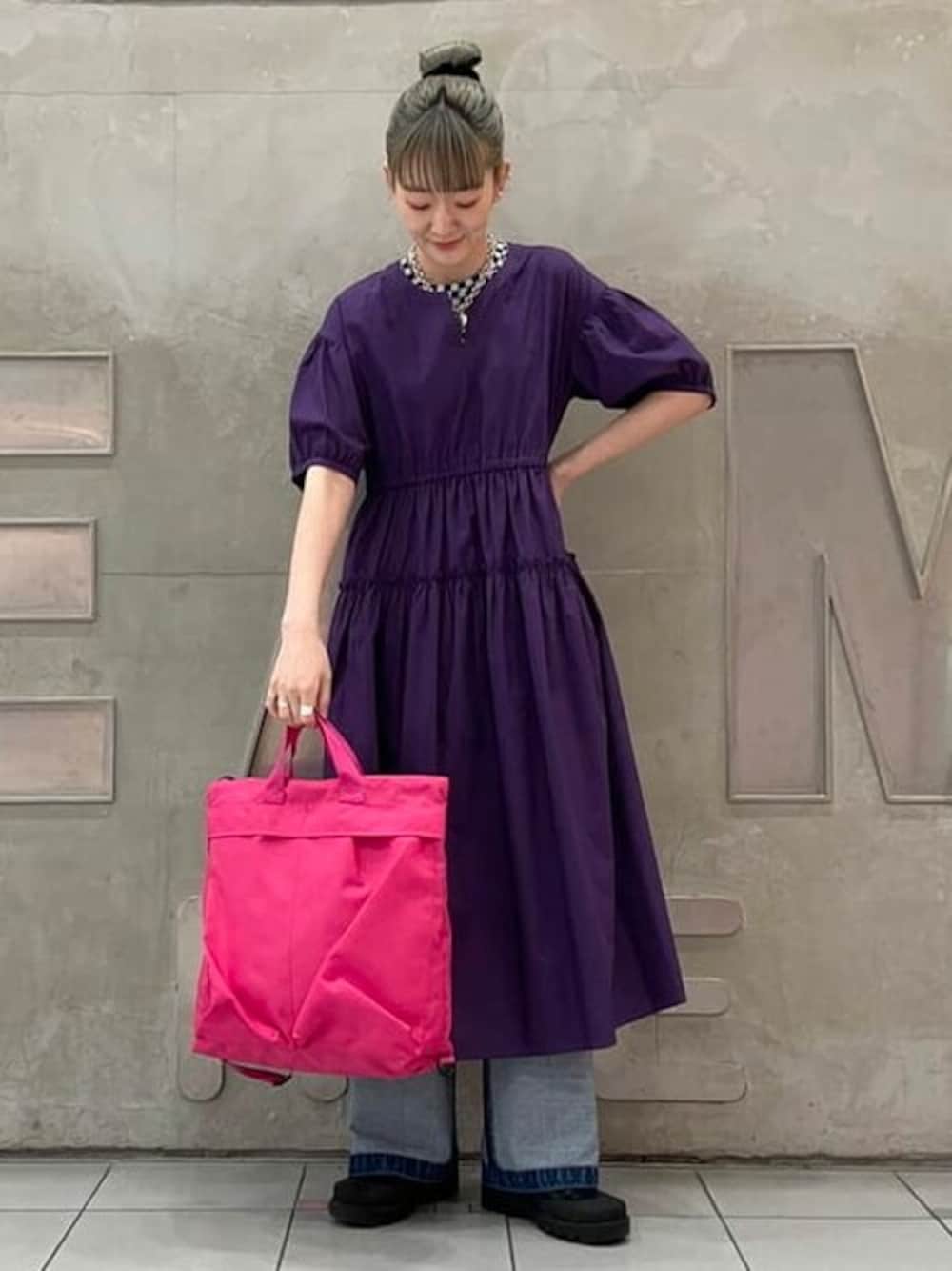 パープル系のワンピース、ブラック系のTシャツ/カットソー、ブルー系のデニムパンツを着用したレディースの夏コーディネートの1枚目の写真