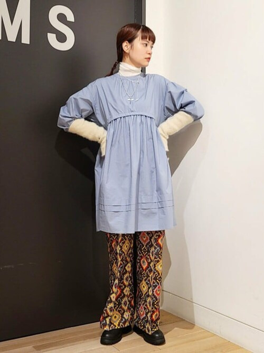 ブルー系のワンピース、ホワイト系のニット/セーター、ブラック系のブーツを着用したレディースの秋コーディネートの1枚目の写真