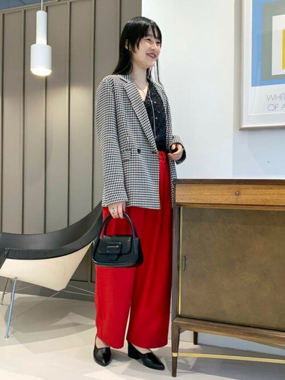 ブラック系のテーラードジャケット、レッド系のその他パンツ、ブラック系のショルダーバッグを着用したレディースの秋コーディネートの1枚目の写真