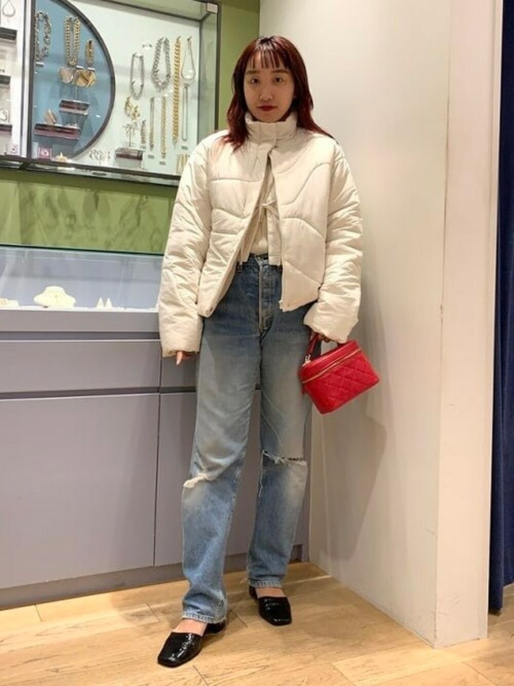 ホワイト系のダウンジャケット/コート、レッド系のハンドバッグを着用したレディースの秋コーディネートの1枚目の写真