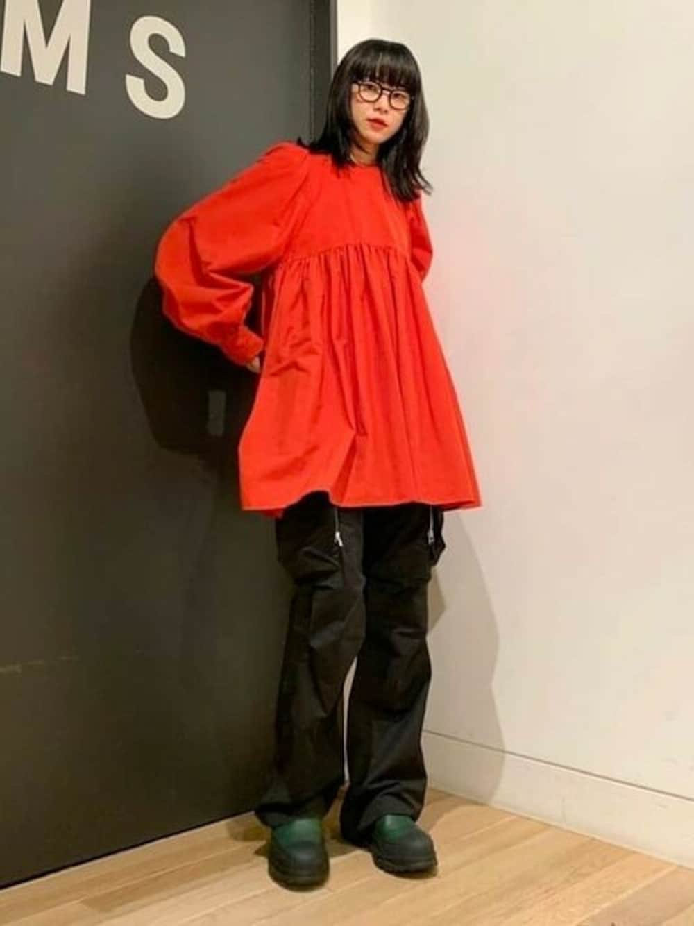 オレンジ系のワンピース、グリーン系のブーツ、ブラック系のカーゴパンツを着用したレディースの秋コーディネートの1枚目の写真