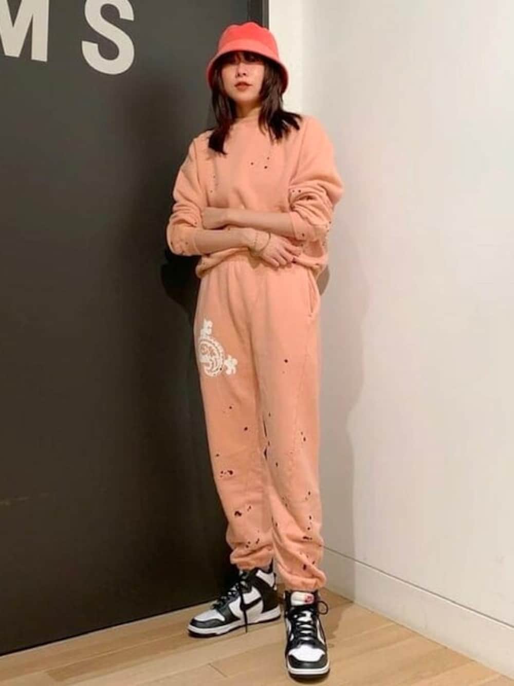 ピンク系のスウェット、ピンク系のその他パンツ、ピンク系のハットを着用したレディースの秋コーディネートの1枚目の写真