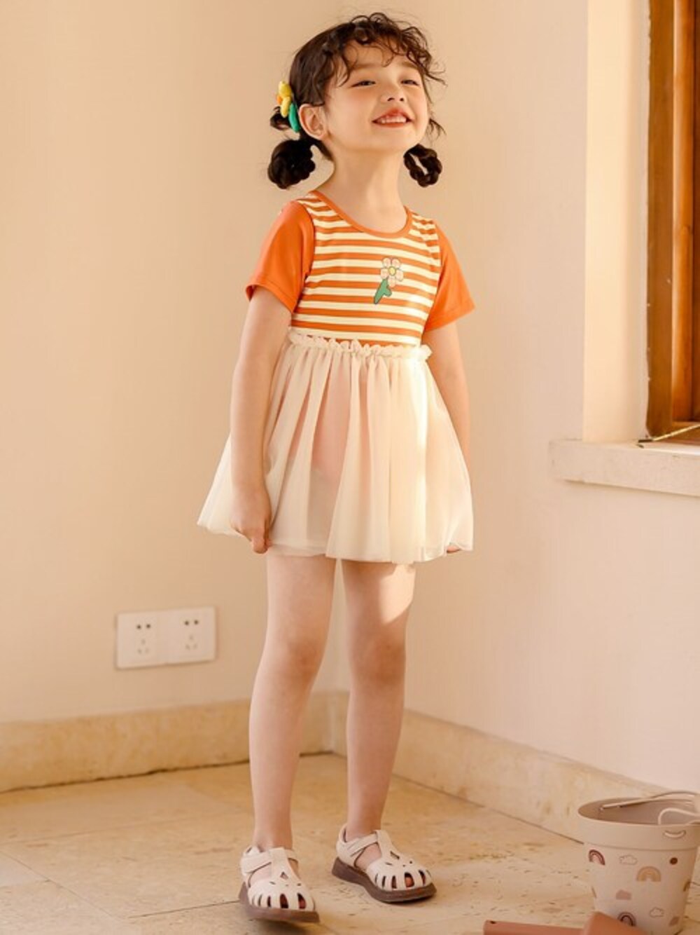 オレンジ系の水着を着用したキッズの夏コーディネートの1枚目の写真