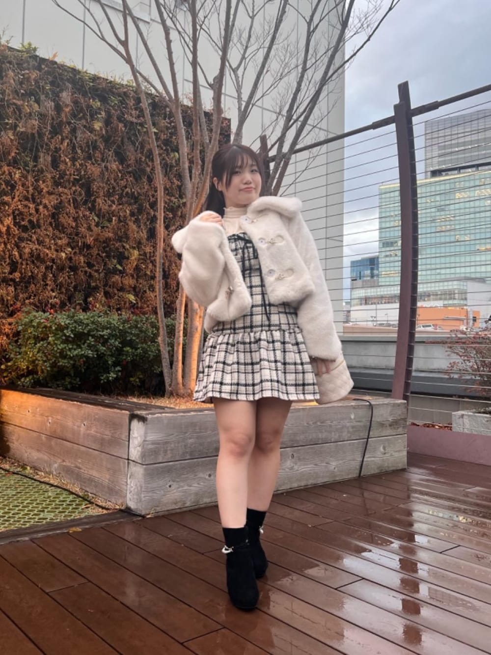 ホワイト系のその他アウター、ホワイト系のショルダーバッグ、ブラック系のブーツを着用したレディースの秋コーディネートの1枚目の写真