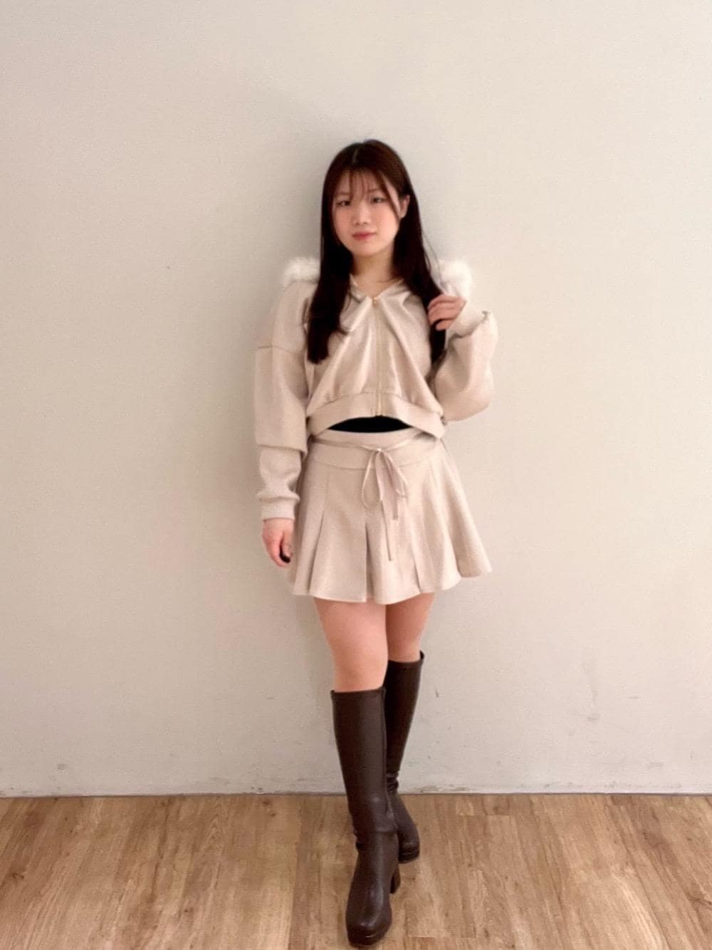 ブラウン系のブーツ、ピンク系のスカート、ピンク系のパーカーを着用したレディースの冬コーディネートの1枚目の写真