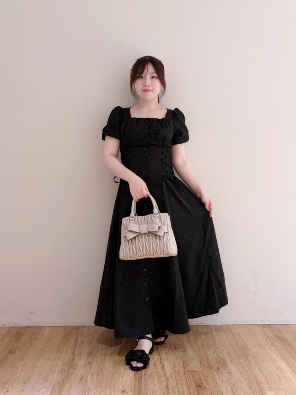 ベージュ系のショルダーバッグ、ブラック系のサンダル、ブラック系のワンピースを着用したレディースの夏コーディネートの1枚目の写真