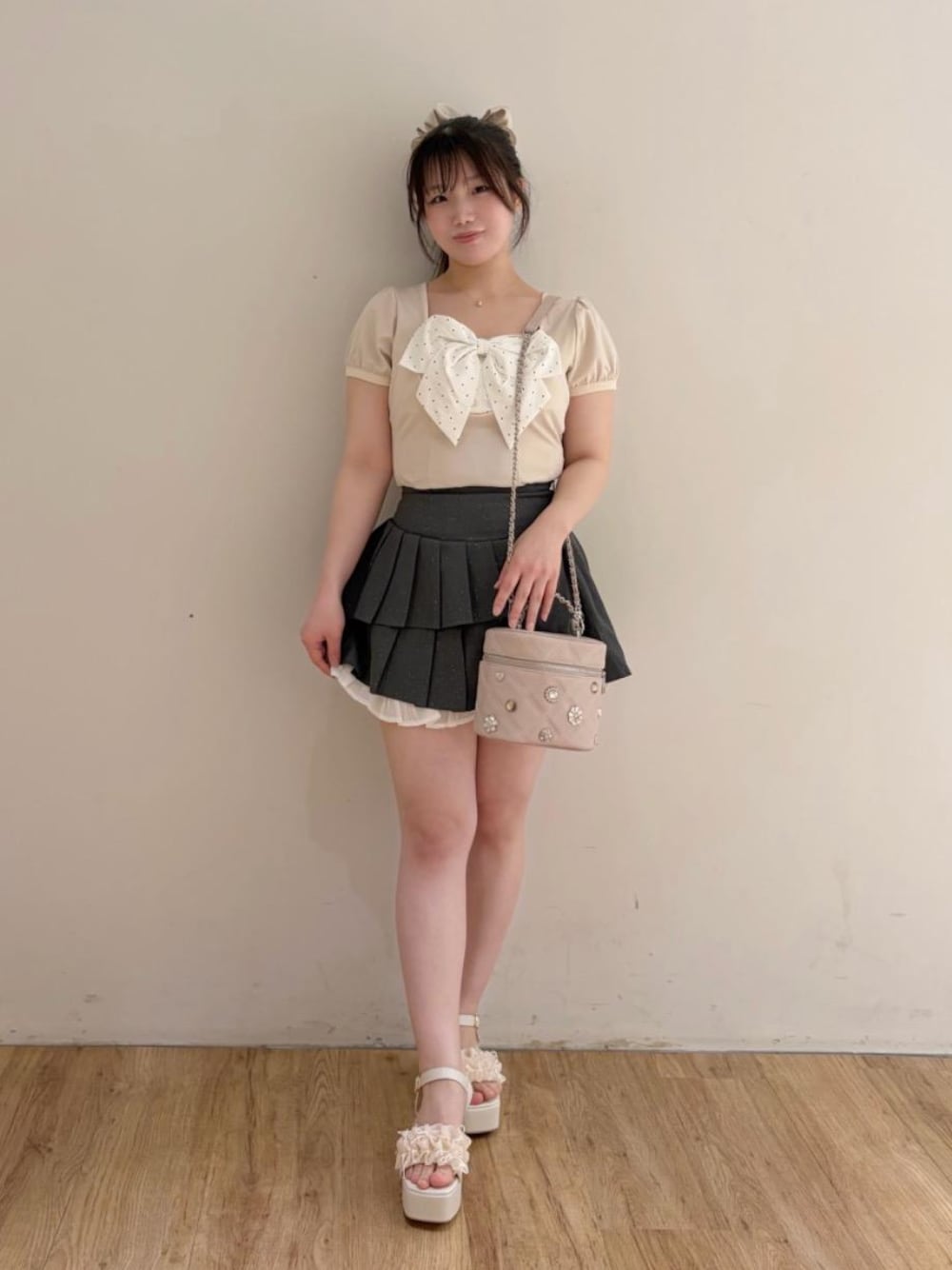 ホワイト系のサンダル、ピンク系のショルダーバッグを着用したレディースの夏コーディネートの1枚目の写真