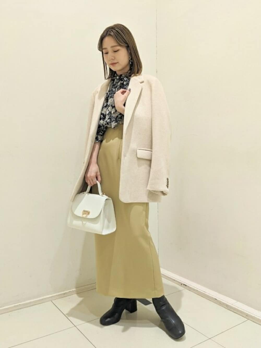 ベージュ系のテーラードジャケット、ブラック系のシャツ/ブラウス、イエロー系のスカートを着用したレディースの秋コーディネートの1枚目の写真
