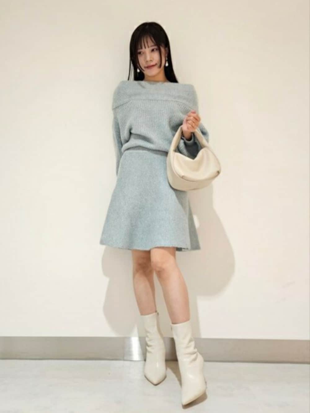 ブルー系のワンピース、ホワイト系のパンプス、ベージュ系のハンドバッグを着用したレディースの秋コーディネートの1枚目の写真