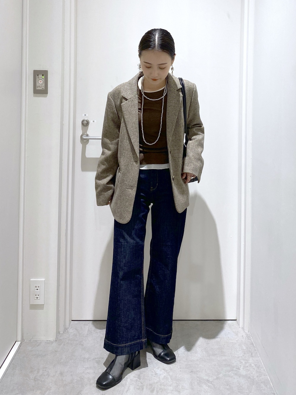 ブラック系のブーツ、ブルー系のデニムパンツ、ベージュ系のテーラードジャケットを着用したレディースの秋コーディネートの1枚目の写真