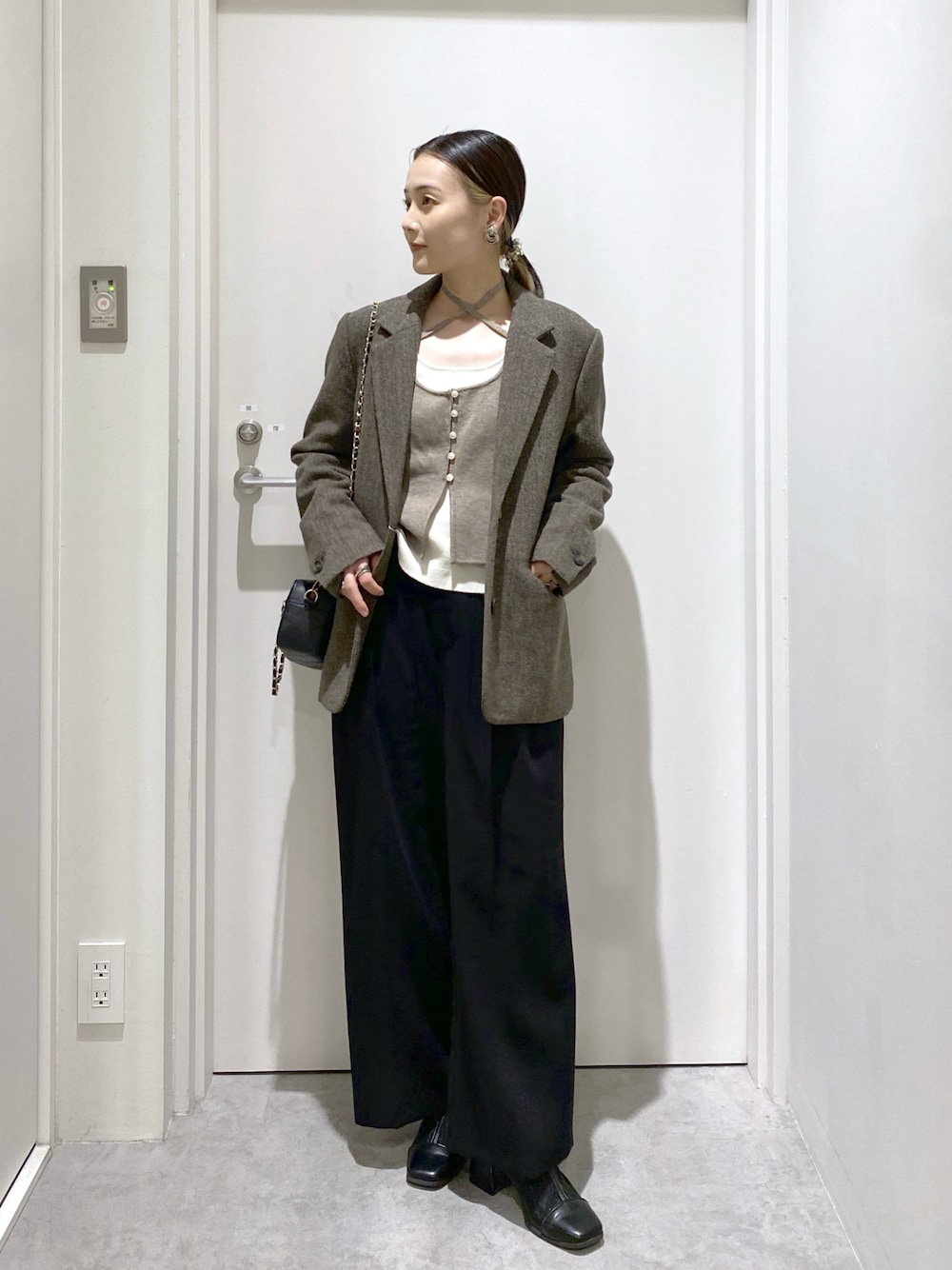 ブラック系のスラックス、ブラウン系のニット/セーター、ブラウン系のテーラードジャケットを着用したレディースの冬コーディネートの1枚目の写真