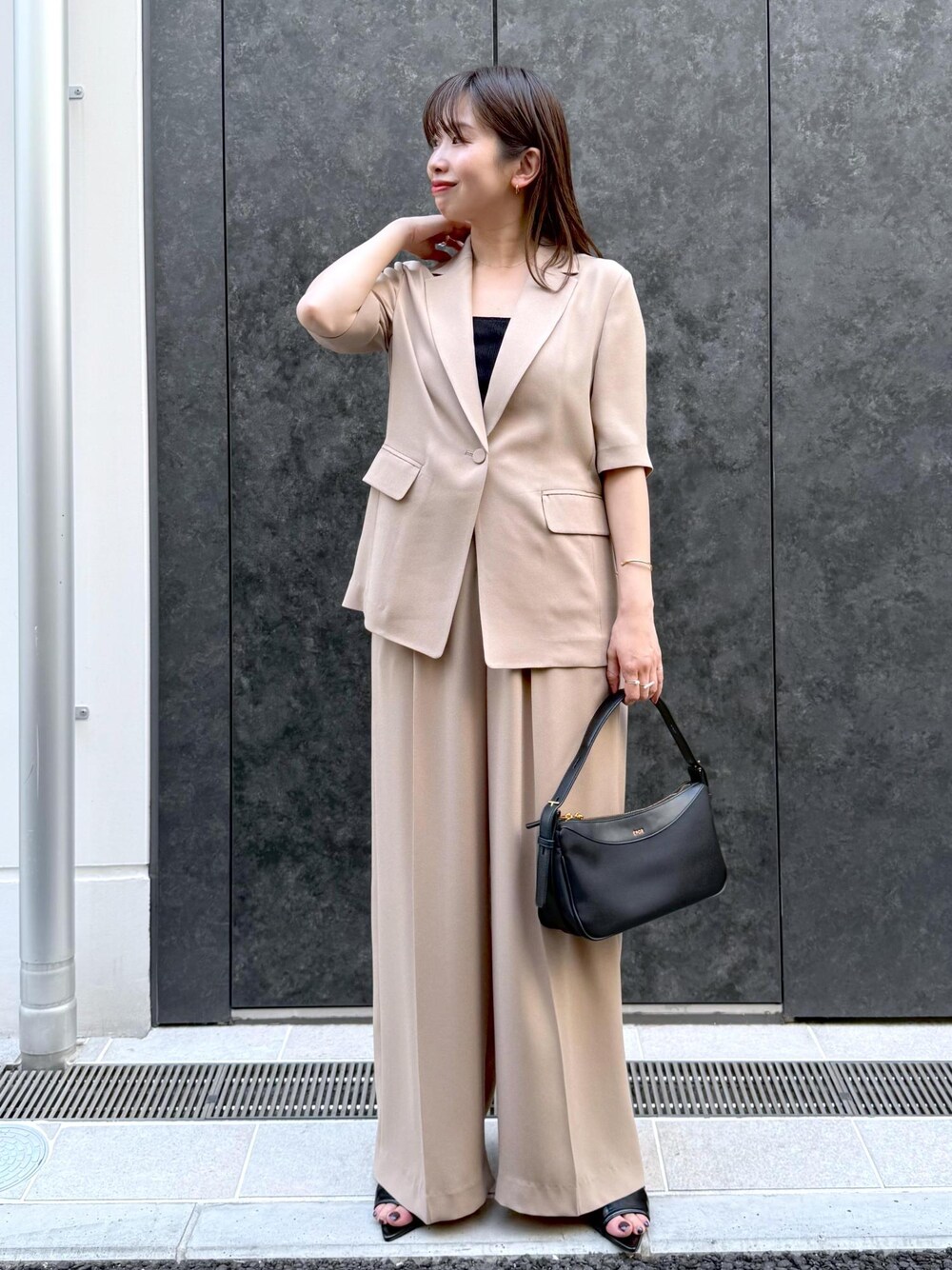 ベージュ系のその他パンツ、ベージュ系のテーラードジャケット、ブラック系のハンドバッグを着用したレディースの夏コーディネートの1枚目の写真