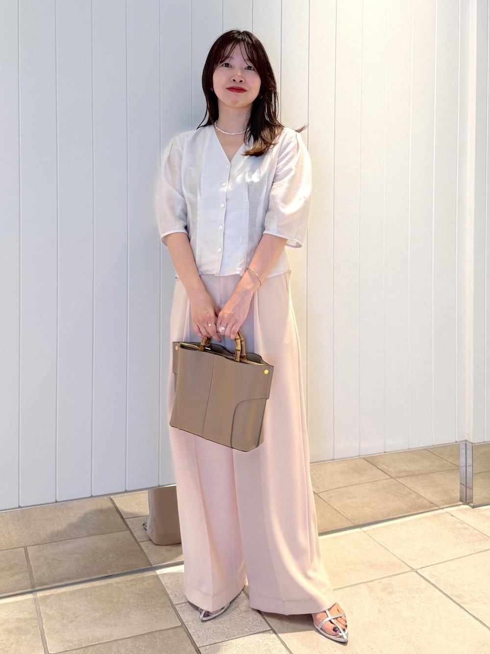 ピンク系のその他パンツ、ホワイト系のシャツ/ブラウス、ベージュ系のハンドバッグを着用したレディースの夏コーディネートの1枚目の写真