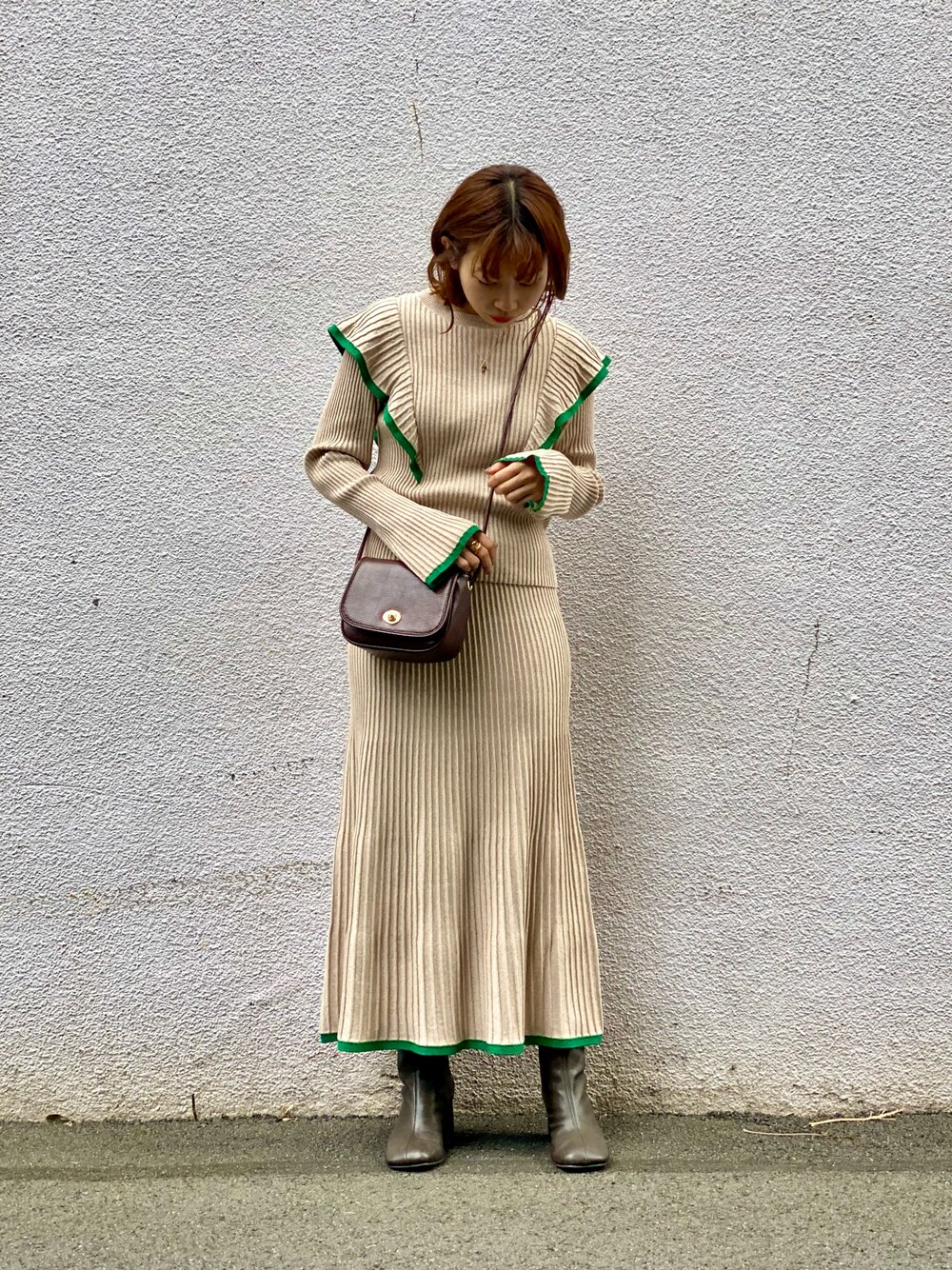 ベージュ系のニット/セーター、ベージュ系のスカート、ブラウン系のショルダーバッグを着用したレディースの冬コーディネートの1枚目の写真