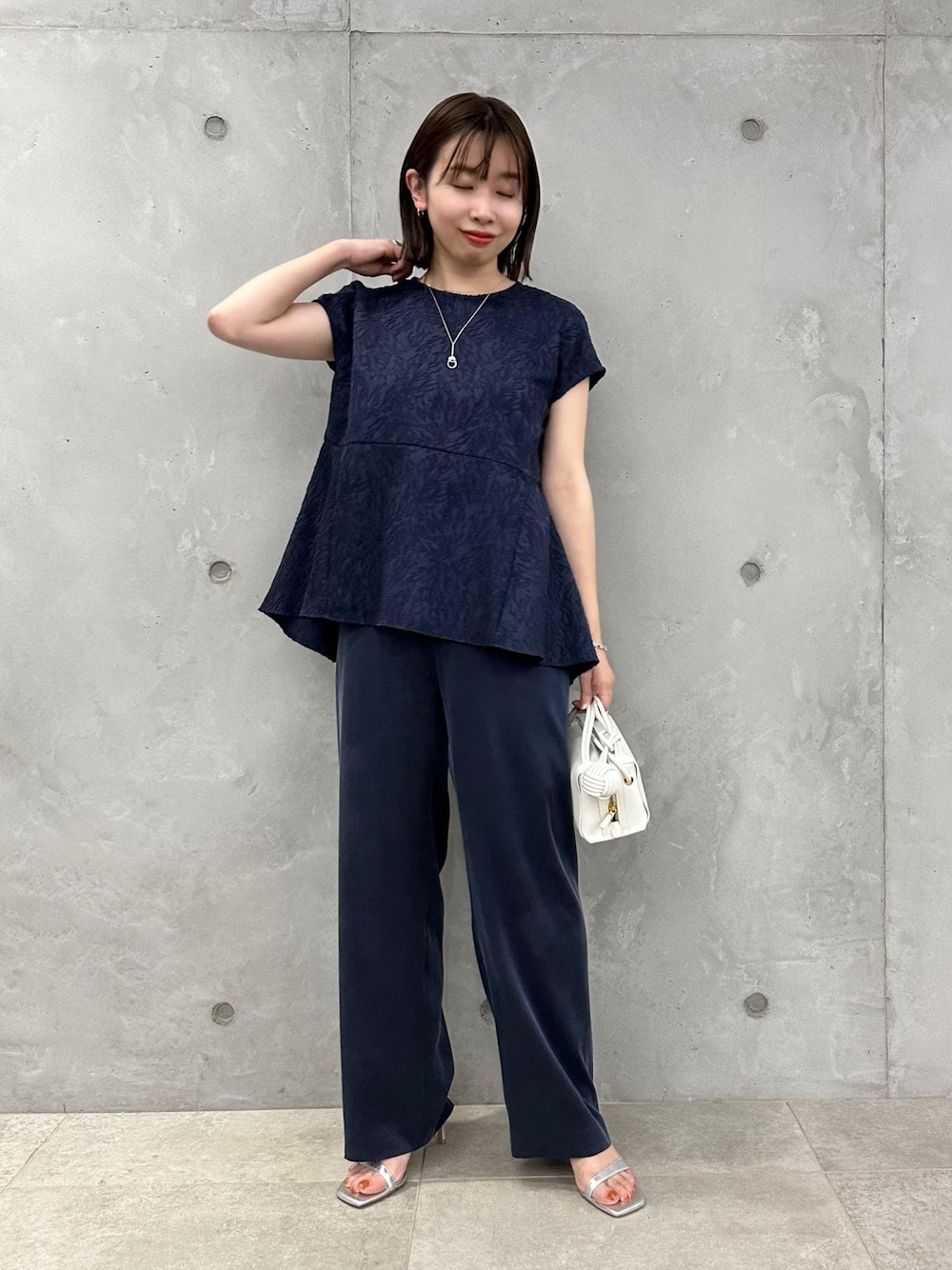 ブルー系のその他パンツ、シルバー系のサンダル、ホワイト系のショルダーバッグを着用したレディースの春コーディネートの1枚目の写真