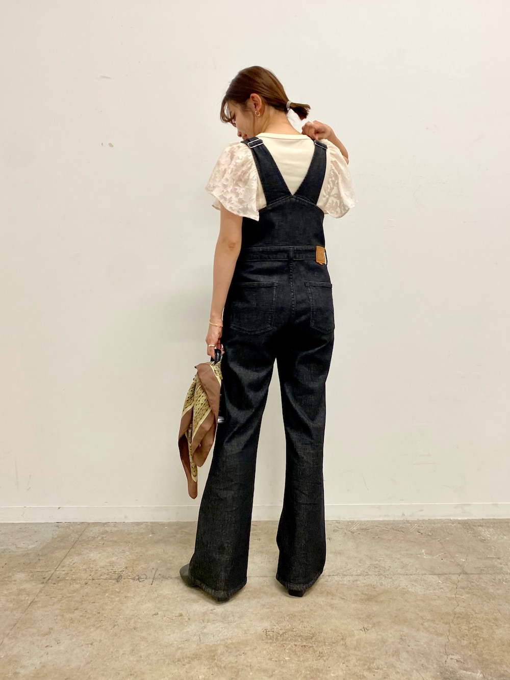 ブラック系のサロペット/オーバーオール、ホワイト系のTシャツ/カットソー、ブラック系のブーツを着用したレディースの夏コーディネートの1枚目の写真