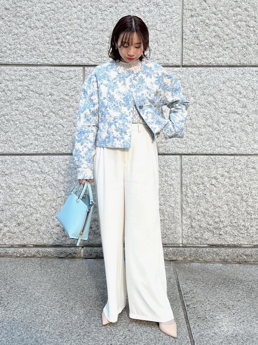 ブルー系のハンドバッグ、ベージュ系のパンプス、ホワイト系のその他パンツを着用したレディースの冬コーディネートの1枚目の写真