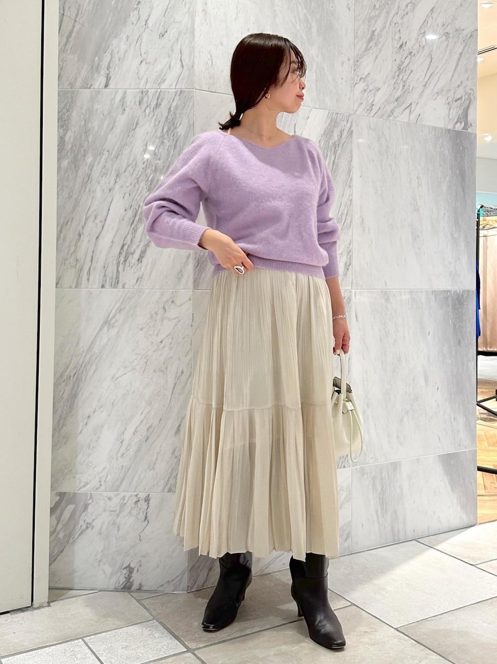 ホワイト系のハンドバッグ、ブラウン系のブーツ、ホワイト系のスカートを着用したレディースの冬コーディネートの1枚目の写真