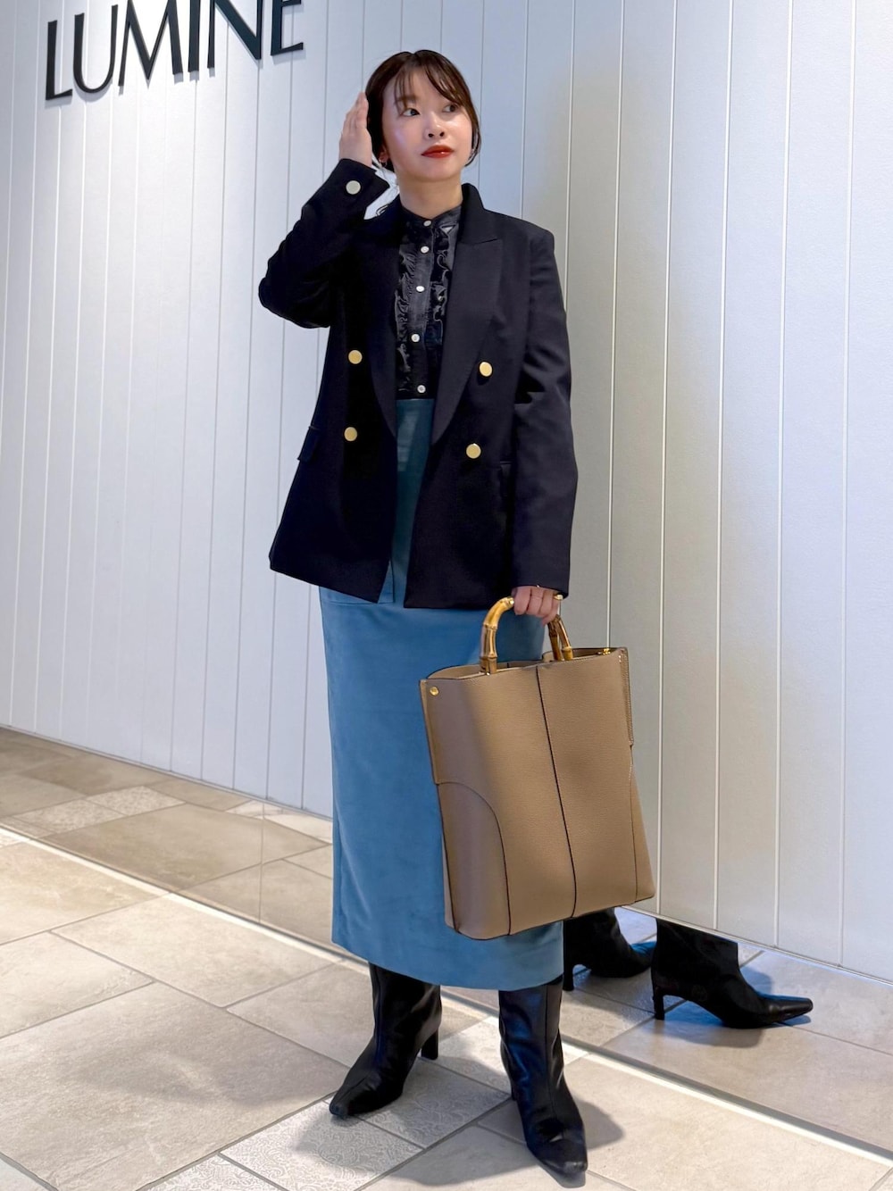 ベージュ系のトートバッグ、ブルー系のスカート、ブルー系のテーラードジャケットを着用したレディースの秋コーディネートの1枚目の写真