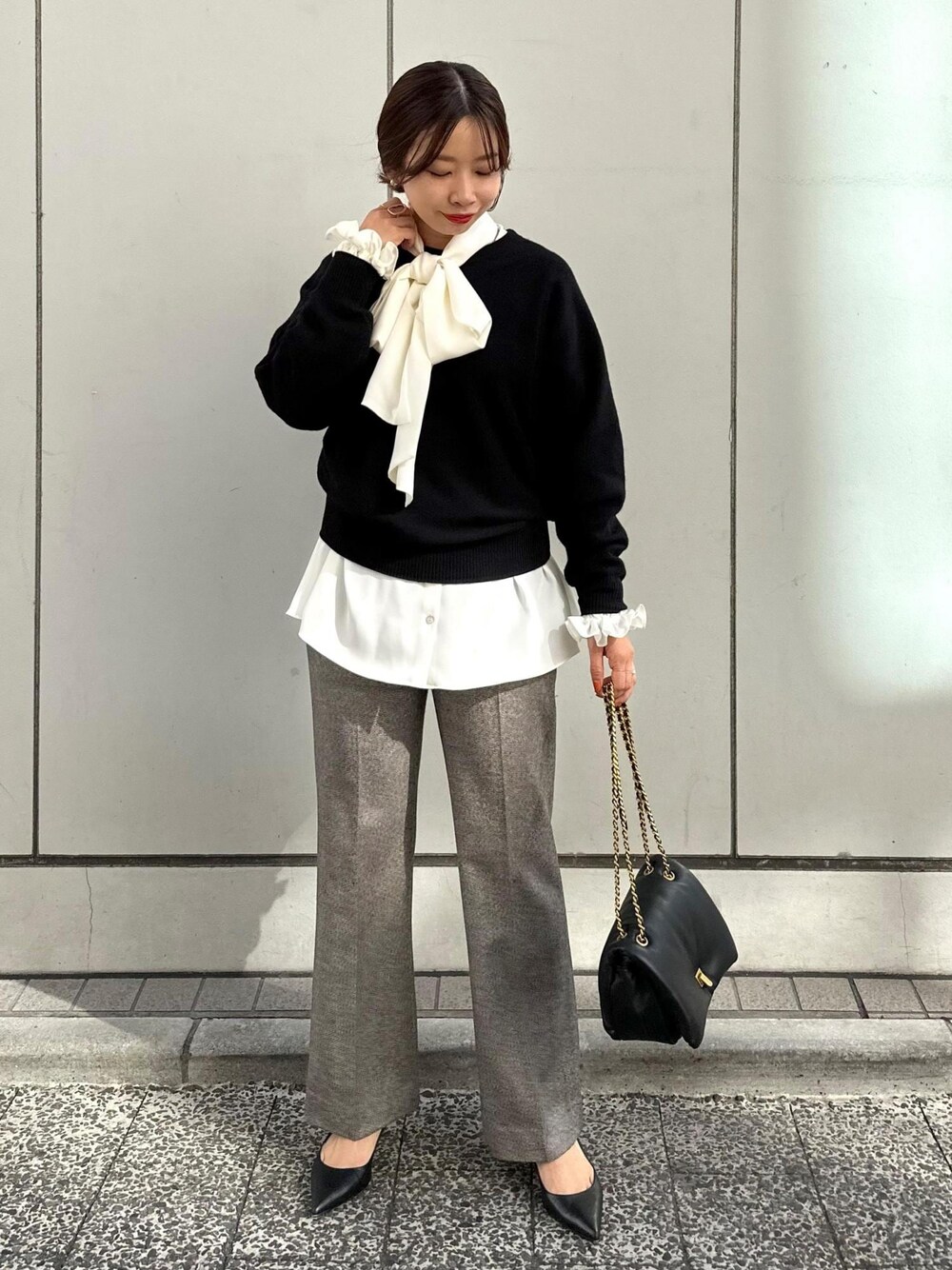 ブラック系のハンドバッグ、ブラック系のパンプス、グレー系のその他パンツを着用したレディースの秋コーディネートの1枚目の写真