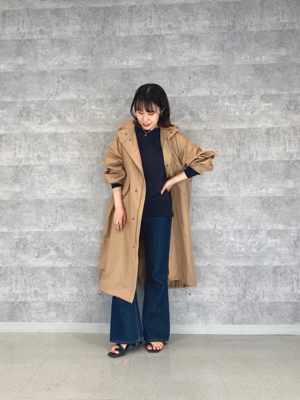 ベージュ系のモッズコート、ブルー系のニット/セーターを着用したレディースの夏コーディネートの1枚目の写真