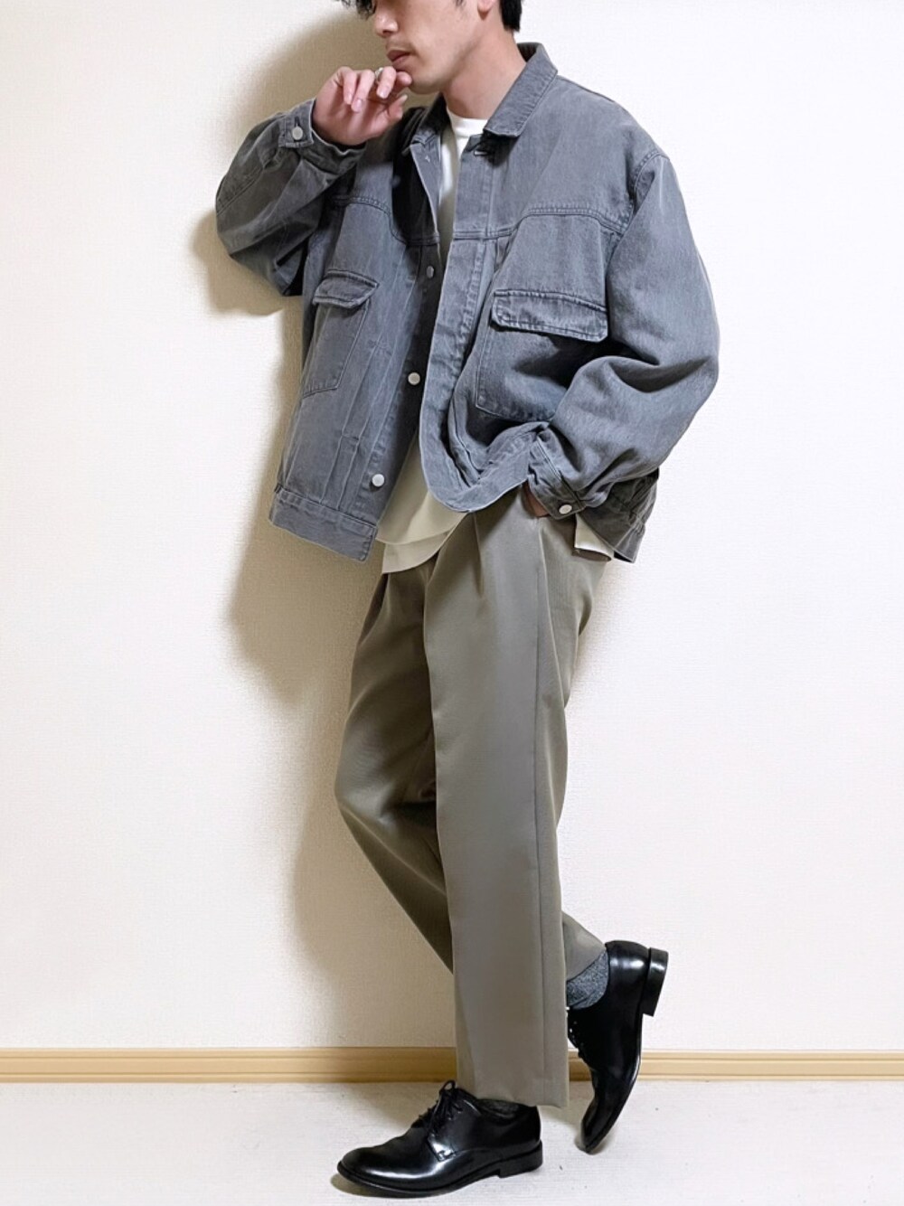 グレー系のセットアップ、ホワイト系のニット/セーター、ホワイト系のタンクトップを着用したメンズの春コーディネートの1枚目の写真