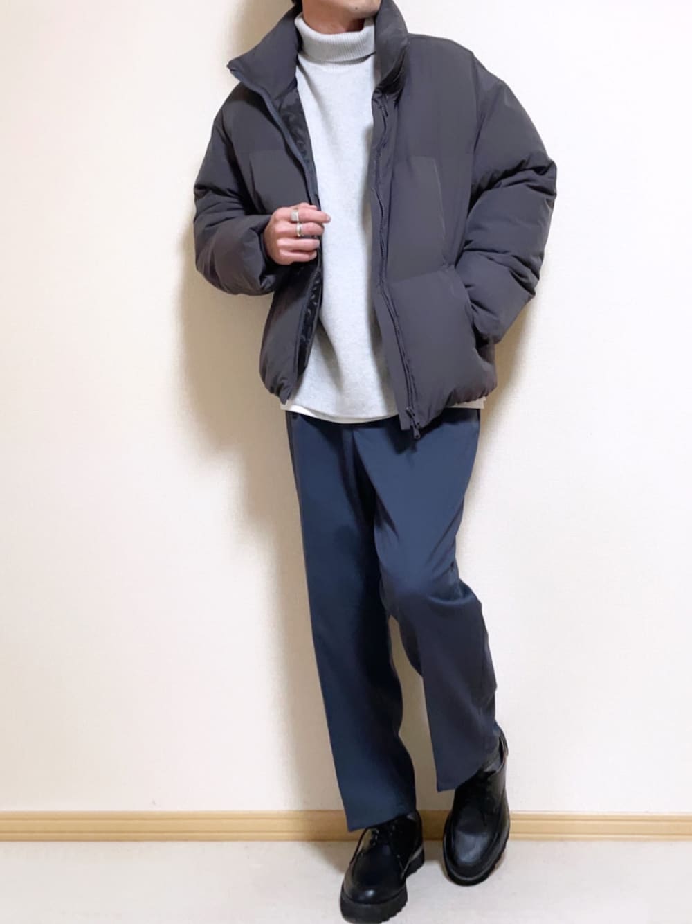 グレー系のダウンジャケット/コート、グレー系のニット/セーター、ホワイト系のタンクトップを着用したメンズの冬コーディネートの1枚目の写真
